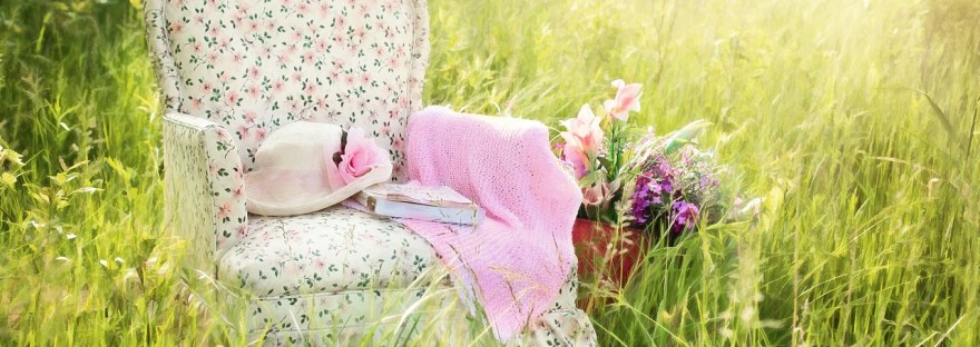 Nojatuoli heinikossa, hattu ja vaate, kesä, voimapuu