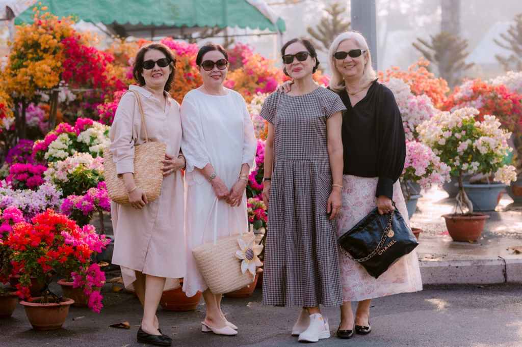 neljä naista, kukkia taustalla. Minä keski-ikäinen nainen, os 2. Voimapuu