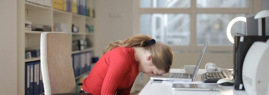 inihimillinen kestävyys, väsynyt nainen nojaa tietokoneeseen